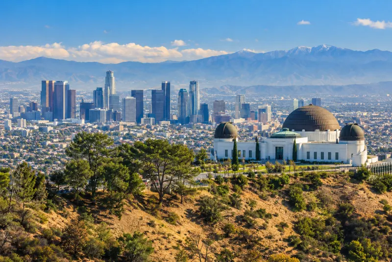 A white domed observatory on a hillside above the downtown skyline in Los Angeles