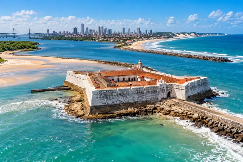 A white star-shaped fort on a rocky point where river meets ocean in Natal