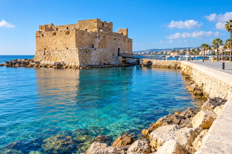 A small stone harbour fort on clear turquoise water in Paphos