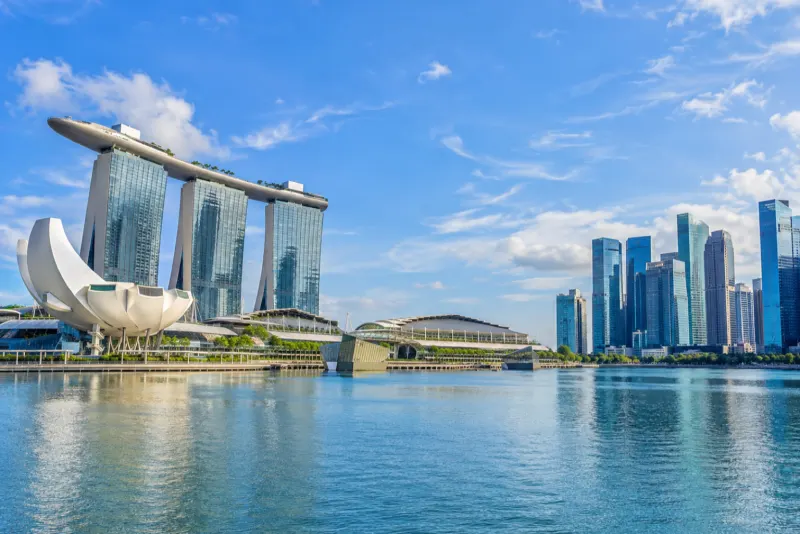 A three-towered hotel with a rooftop deck and a lotus-shaped museum beside the bay in Singapore