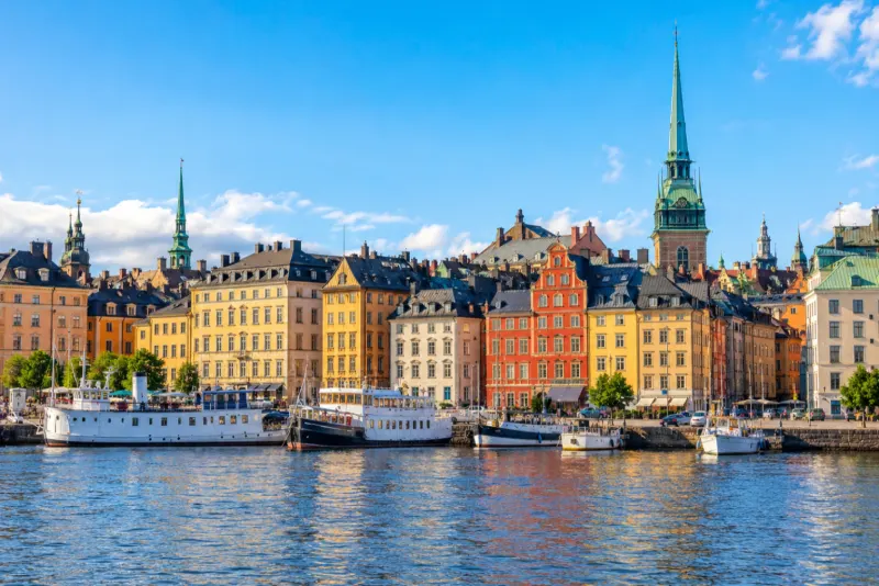 Colourful old-town buildings and green church spires along the waterfront in Stockholm
